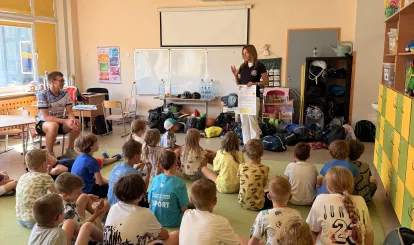 Półkolonie dla dzieci organizowane przez UKS Fala. - Na zdjęciu grupa dzieci słuchająca wykładu o bezpieczęństwie.